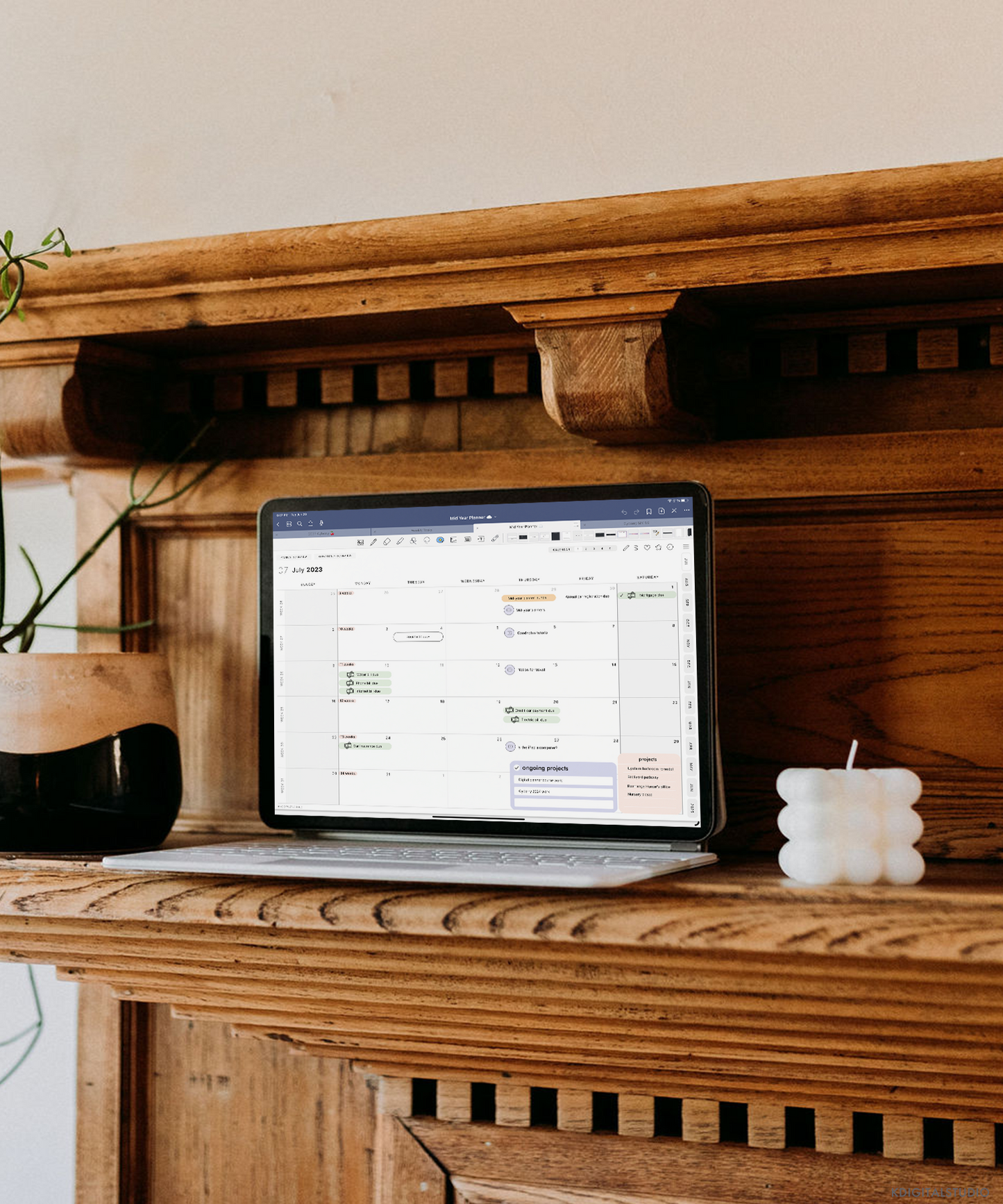 An iPad Pro attached to the Magic Keyboard is sitting on the mantle of a fireplace. Displayed on the iPad is the 2023-2024 Cyberry Mid-Year Digital Planner.