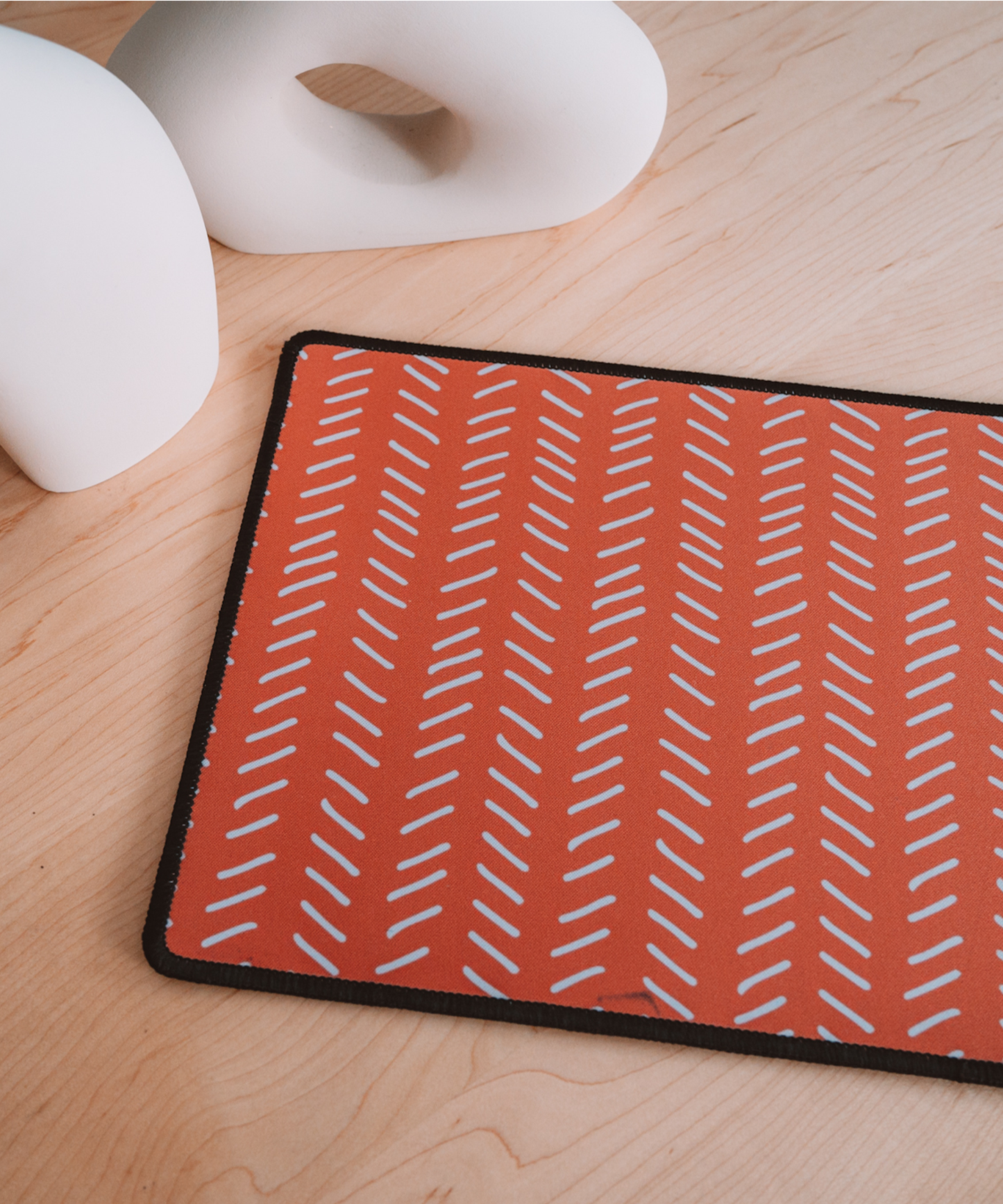 The Harrow mousepad laying on a desk near asymmetrical vases