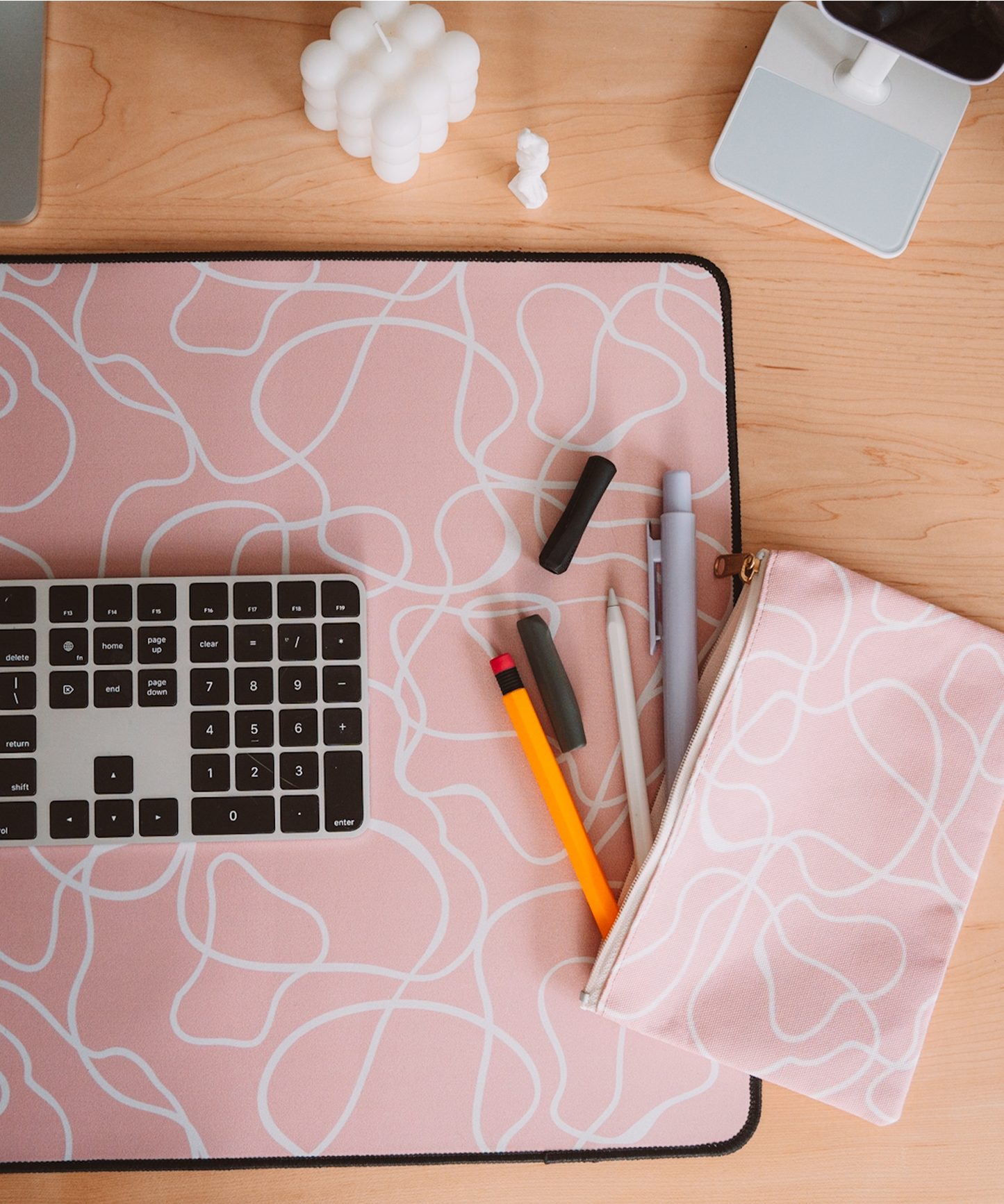 A topdown shot of a desk, featuring the Terrain desk mat and Terrain accessory pouch