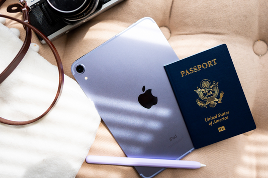 A purple iPad mini with a US passport and vintage film camera