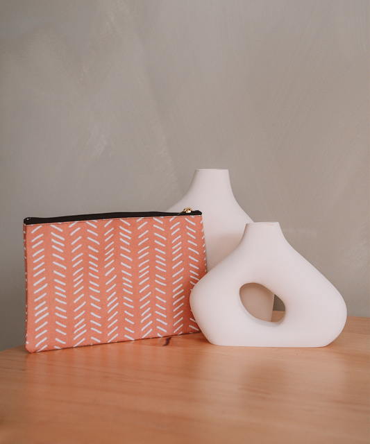 The Harrow accessory pouch is leaned against two asymmetrical vases